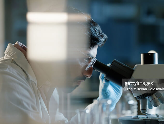 Scientist looking through a microscope in a laboratory setting